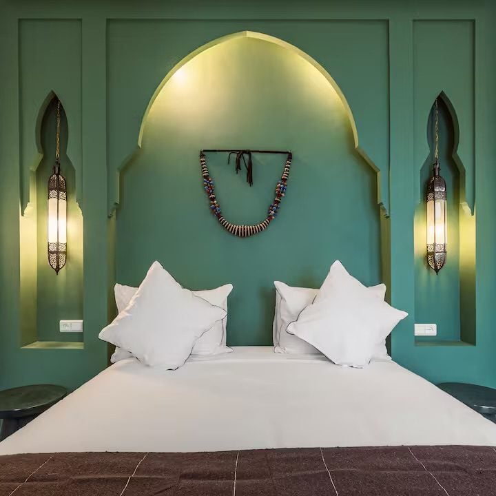 Chambre Verte de Riad Sasha, alcôve en arc vert sauge et collier berbère en tête de lit