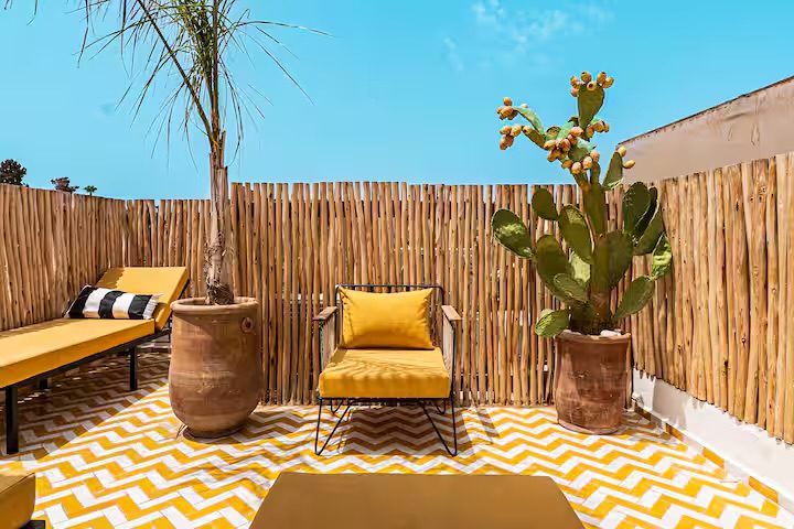 Terrasse ensoleillée de Riad Sasha, carrelage graphique jaune et mobilier ocre